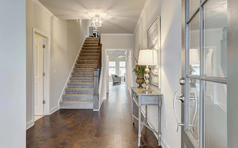Wide view of a home entryway with a stairwell on the left.